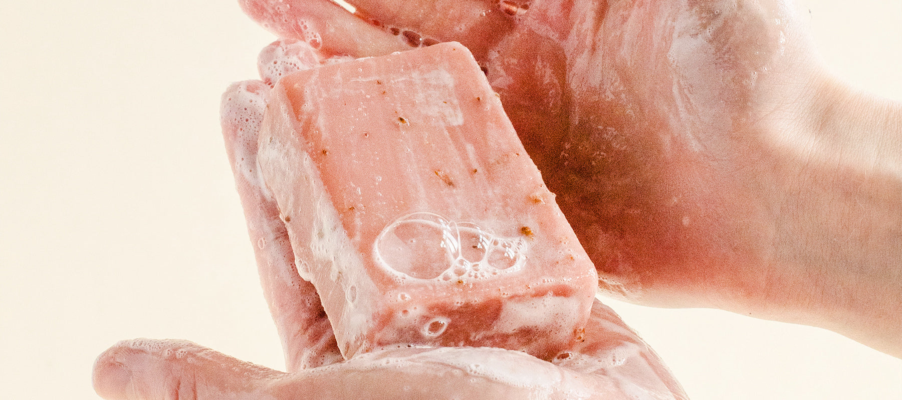 Bar of lathered natural soap in a pair of hands.